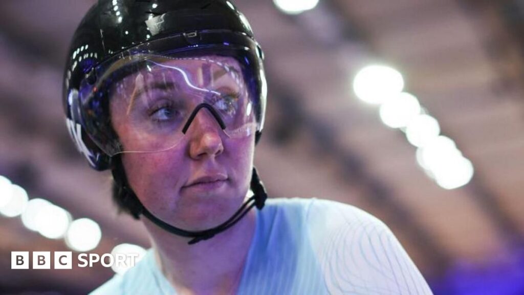 Katie Archibald riding on the velodrome track wearing her Great Britain cycling kit and helmet