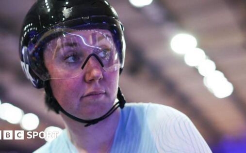 Katie Archibald riding on the velodrome track wearing her Great Britain cycling kit and helmet