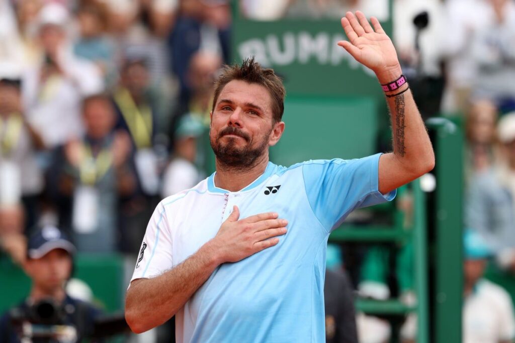 Stan Wawrinka hitting a backhand on a clay court during a tennis match
