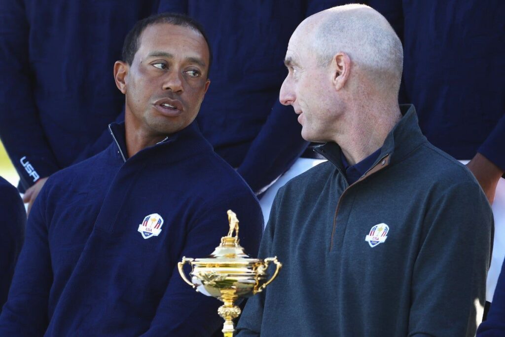 Jim Furyk and Tiger Woods conversing on a golf course during a previous Ryder Cup tournament
