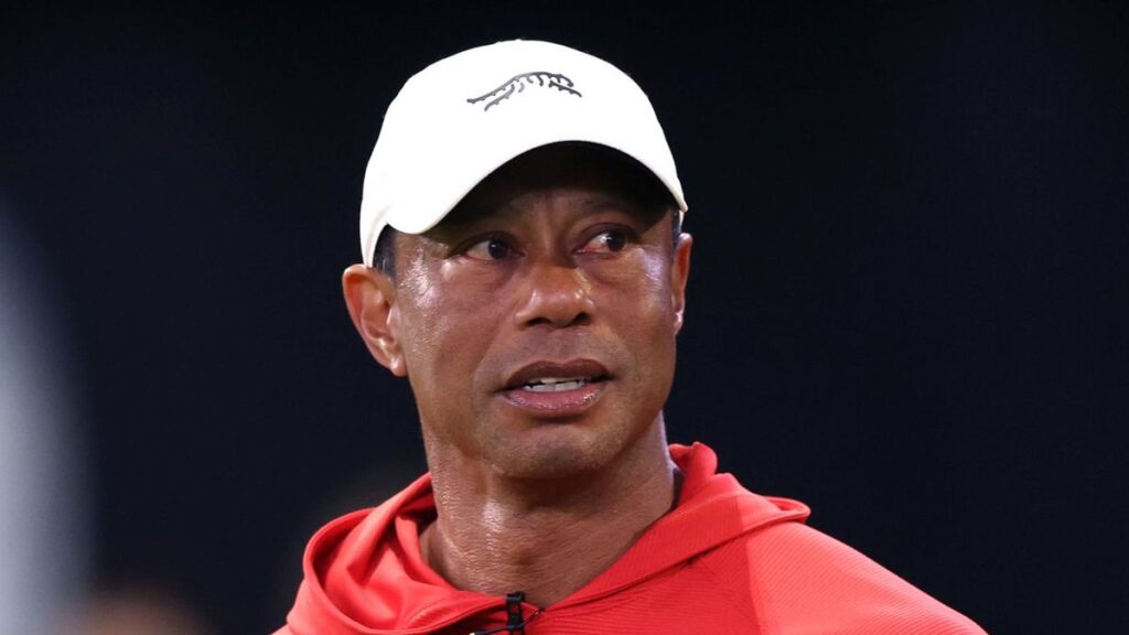 Tiger Woods walking on a golf course looking serious