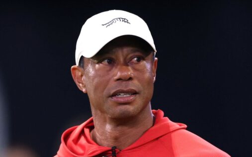 Tiger Woods walking on a golf course looking serious