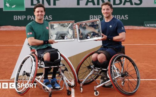 Alfie Hewett and Gordon Reid holding their French Open wheelchair doubles championship trophies on a clay court