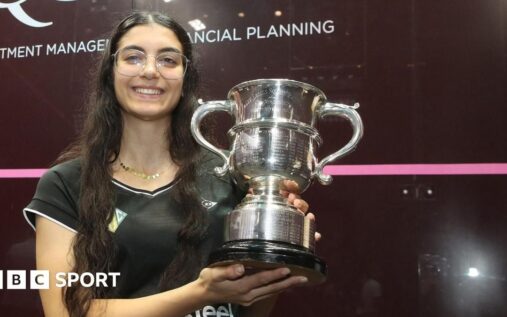 Amina Orfi holding the British Open squash trophy and celebrating her historic victory