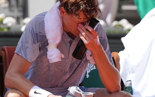 Jannik Sinner looking physically exhausted on a clay court during his French Open match