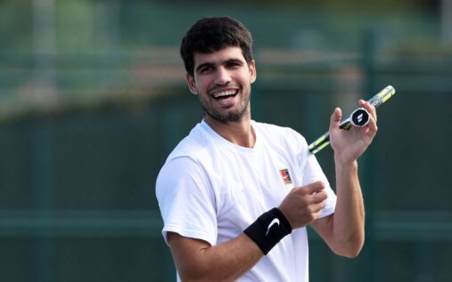 Carlos Alcaraz looking dejected on a tennis court holding his tennis racquet