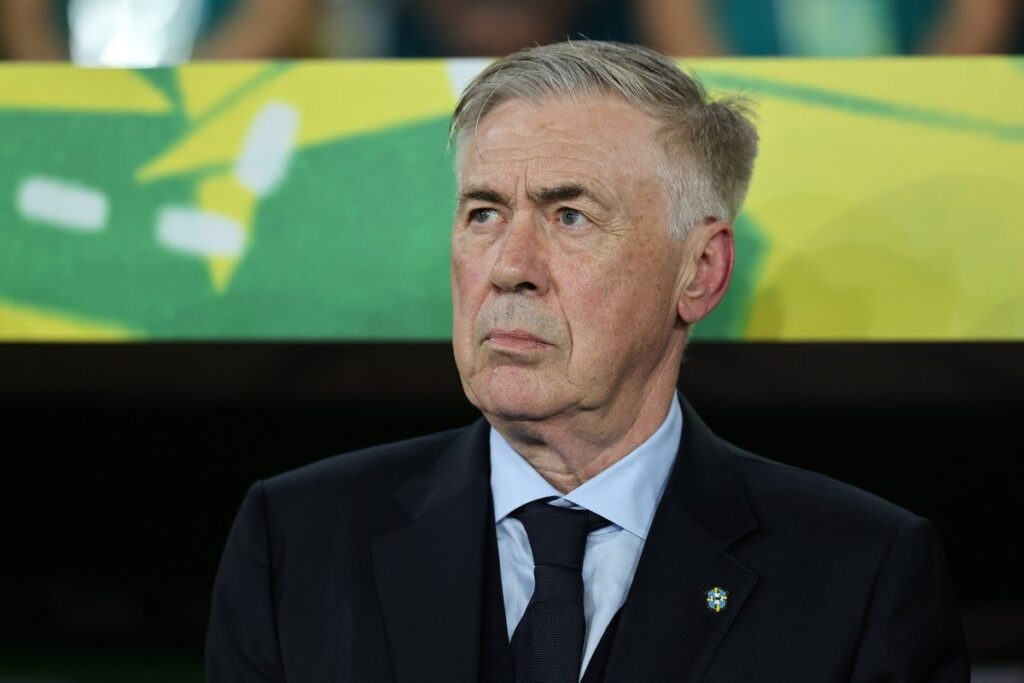 Carlo Ancelotti standing on the touchline in a suit managing his team
