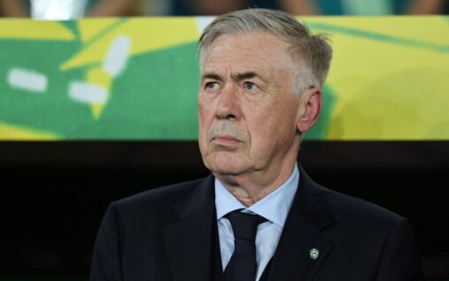 Carlo Ancelotti standing on the touchline in a suit managing his team