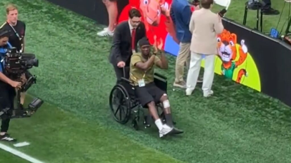 Ismael Kone in a wheelchair being wheeled onto the pitch at BC Place