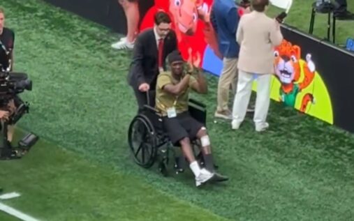 Ismael Kone in a wheelchair being wheeled onto the pitch at BC Place