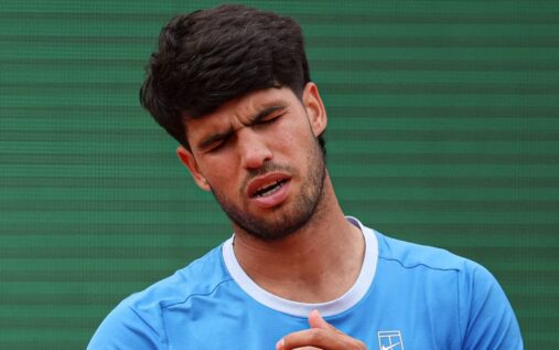 Carlos Alcaraz walking off a tennis court looking dejected after withdrawing from a tournament