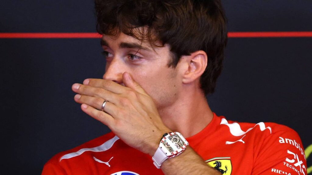 Charles Leclerc wearing his red Ferrari race suit in the Formula 1 paddock
