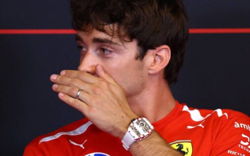 Charles Leclerc wearing his red Ferrari race suit in the Formula 1 paddock