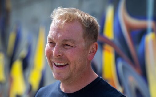 Sir Chris Hoy smiling while participating in a charity cycling event