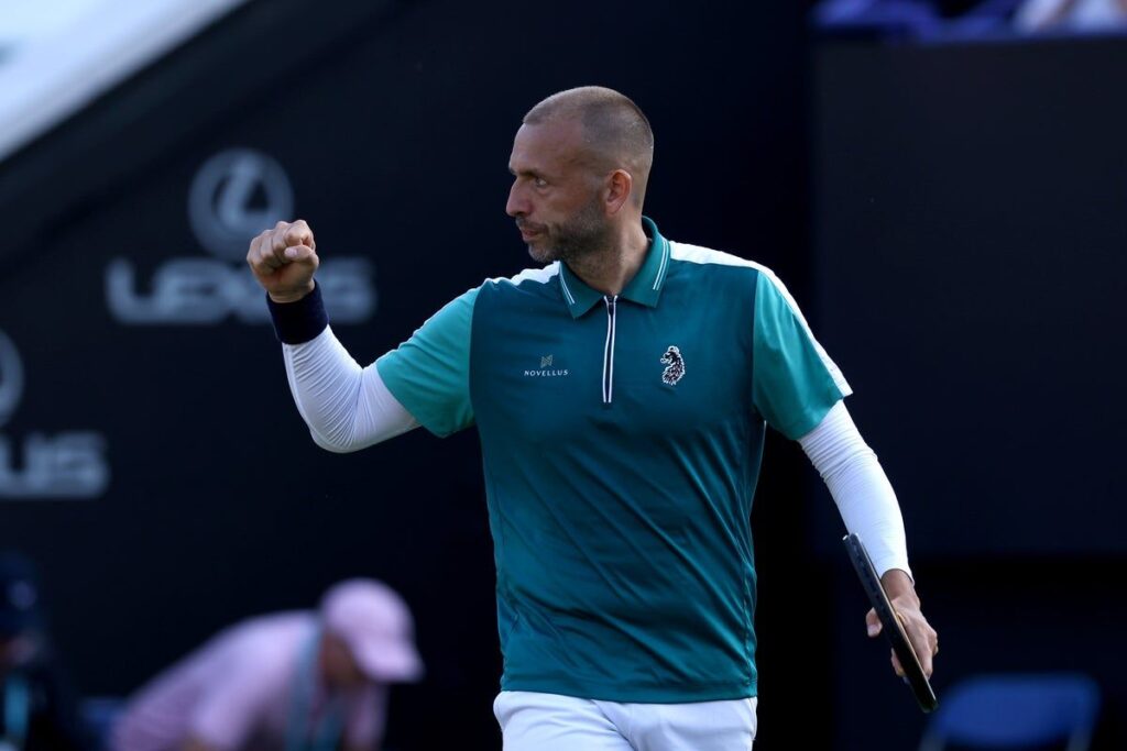 Dan Evans waving and acknowledging the crowd on a tennis court