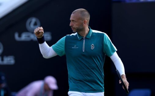 Dan Evans waving and acknowledging the crowd on a tennis court
