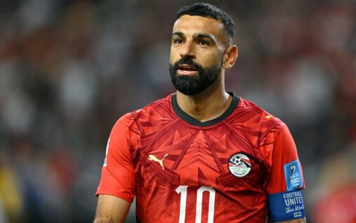 Mohamed Salah sitting on the substitutes bench with an ice pack on his left knee