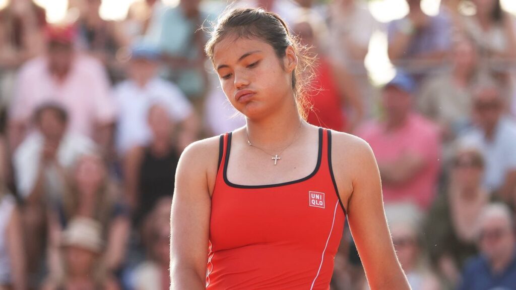 Emma Raducanu looking disappointed on a tennis court during a match