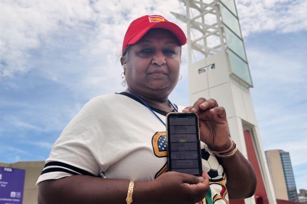 Frustrated football fans standing outside a World Cup stadium looking at their mobile phones