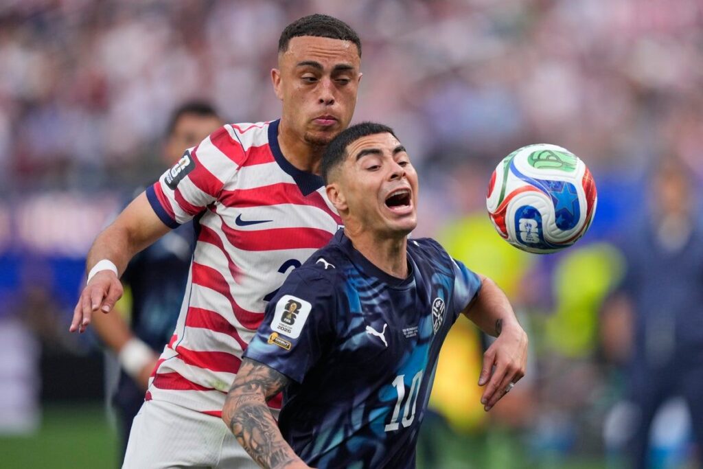 Referee reviewing a pitchside VAR monitor during a World Cup football match