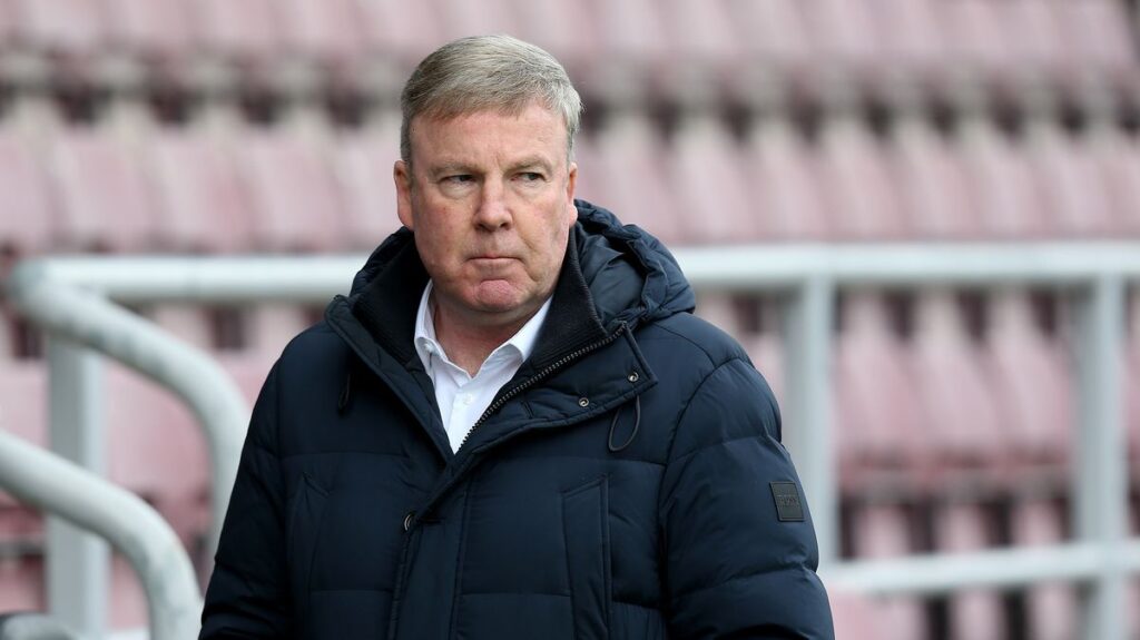 Former football manager Kenny Jackett standing on the touchline observing a match