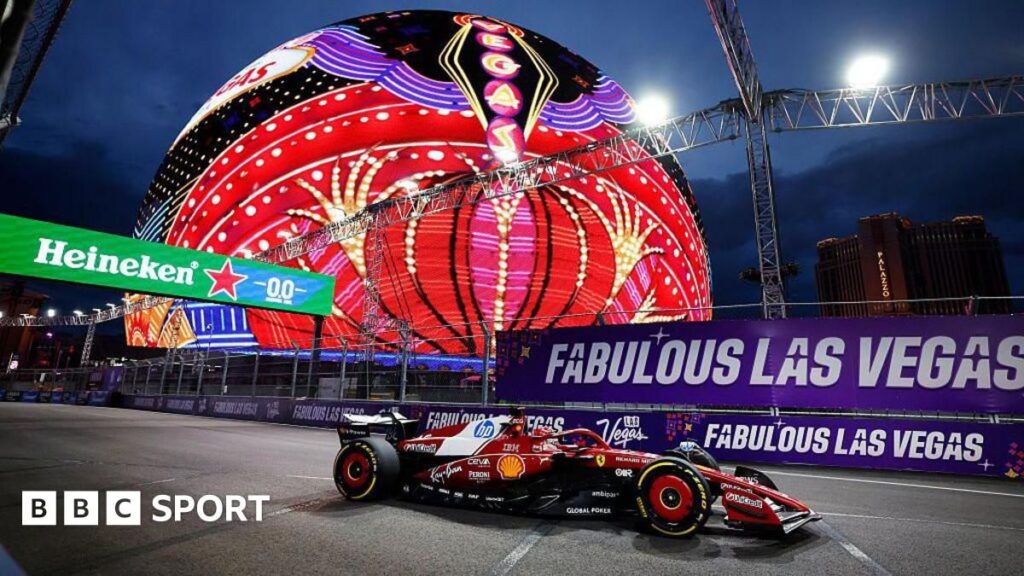 Formula 1 cars racing down the famous Las Vegas Strip at night past iconic casino hotels