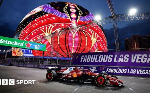 Formula 1 cars racing down the famous Las Vegas Strip at night past iconic casino hotels
