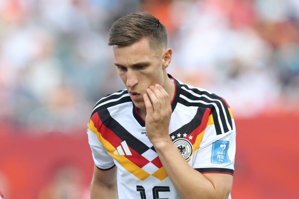 Germany defender Nico Schlotterbeck looking dejected on the pitch during a World Cup match