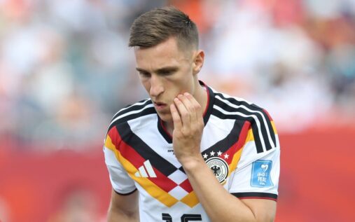 Germany defender Nico Schlotterbeck looking dejected on the pitch during a World Cup match