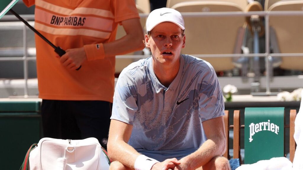 Jannik Sinner looking serious on a tennis court during a Grand Slam tournament