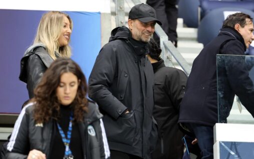 Jurgen Klopp smiling on the touchline while wearing his trademark glasses