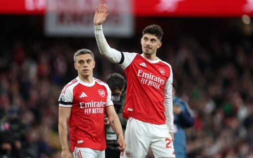 Kai Havertz wearing an Arsenal kit pointing to the club badge on his chest.