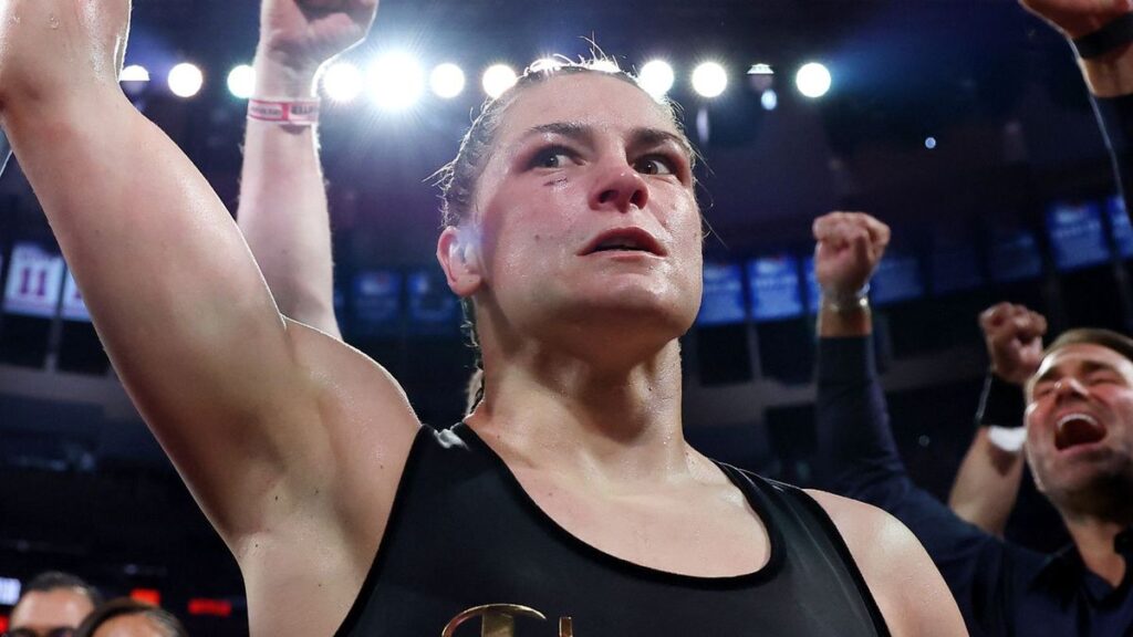 Katie Taylor posing with her undisputed super lightweight championship boxing belts
