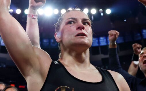 Katie Taylor posing with her undisputed super lightweight championship boxing belts