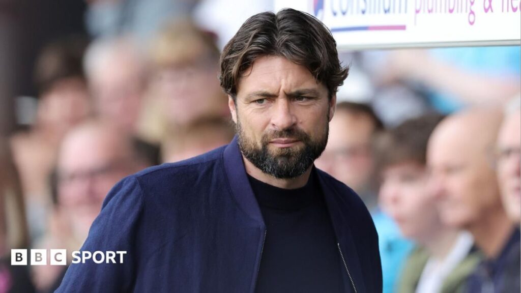 Russell Martin standing on the touchline wearing a manager's suit