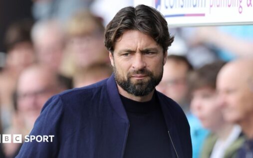 Russell Martin standing on the touchline wearing a manager's suit