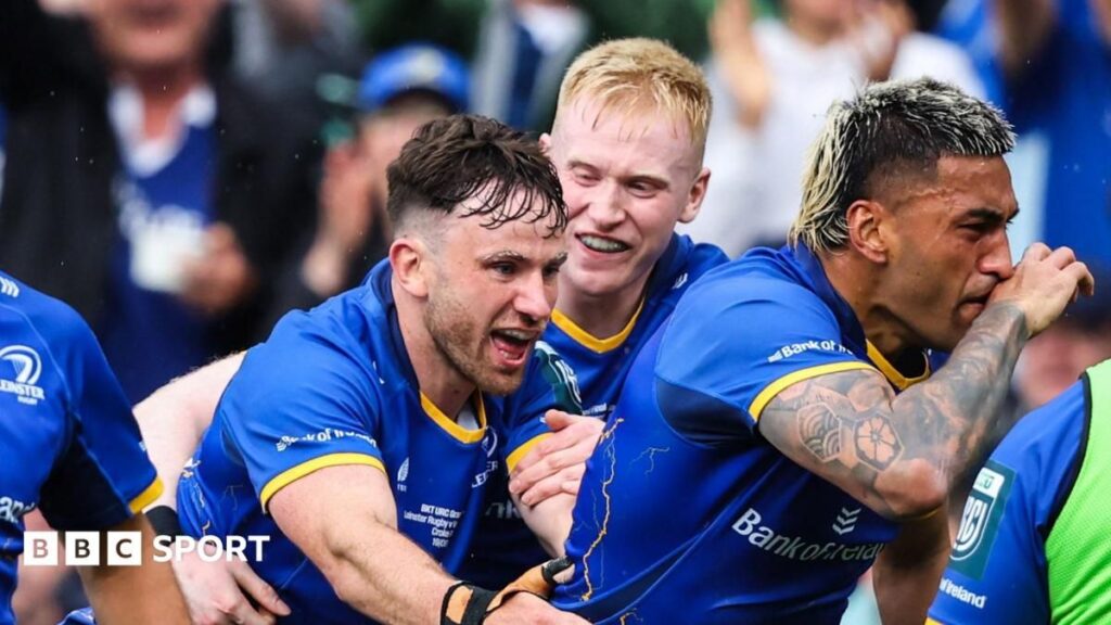 Leinster rugby players lifting the United Rugby Championship trophy while celebrating their victory over the Bulls