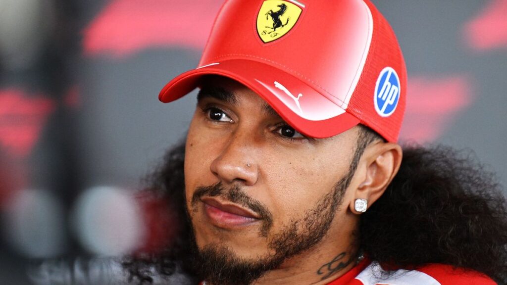 Lewis Hamilton wearing his red Ferrari racing suit in the Formula 1 paddock during the 2026 season