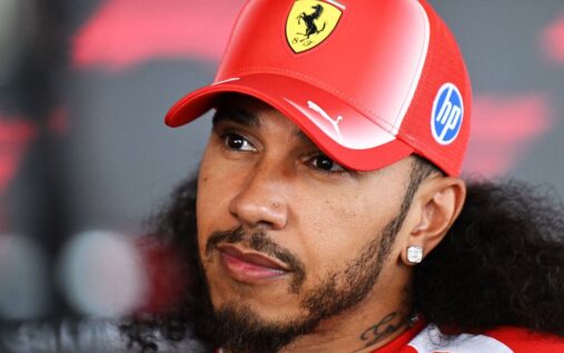 Lewis Hamilton wearing his red Ferrari racing suit in the Formula 1 paddock during the 2026 season