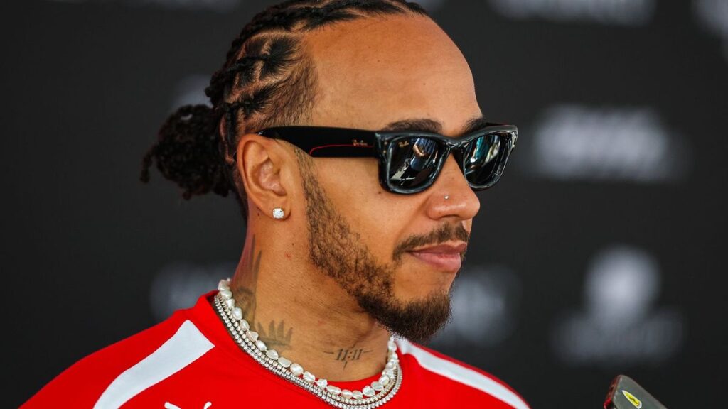 Lewis Hamilton wearing his red Ferrari race suit in the Formula 1 paddock
