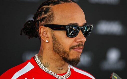 Lewis Hamilton wearing his red Ferrari race suit in the Formula 1 paddock