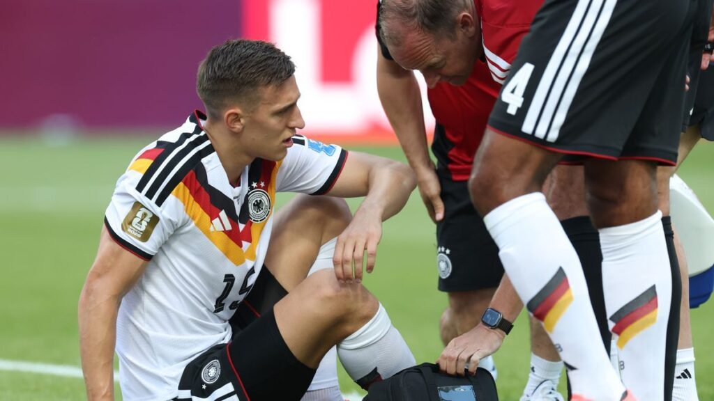 Nico Schlotterbeck receiving medical treatment on the pitch during Germany's World Cup match against Ivory Coast