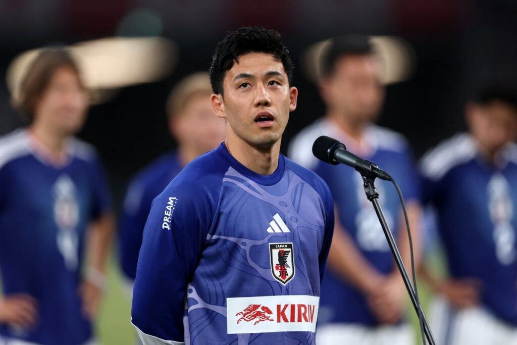 Wataru Endo wearing the Japan national team kit looking emotional on the pitch