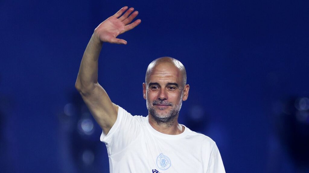 Pep Guardiola standing on the touchline gesturing during a match