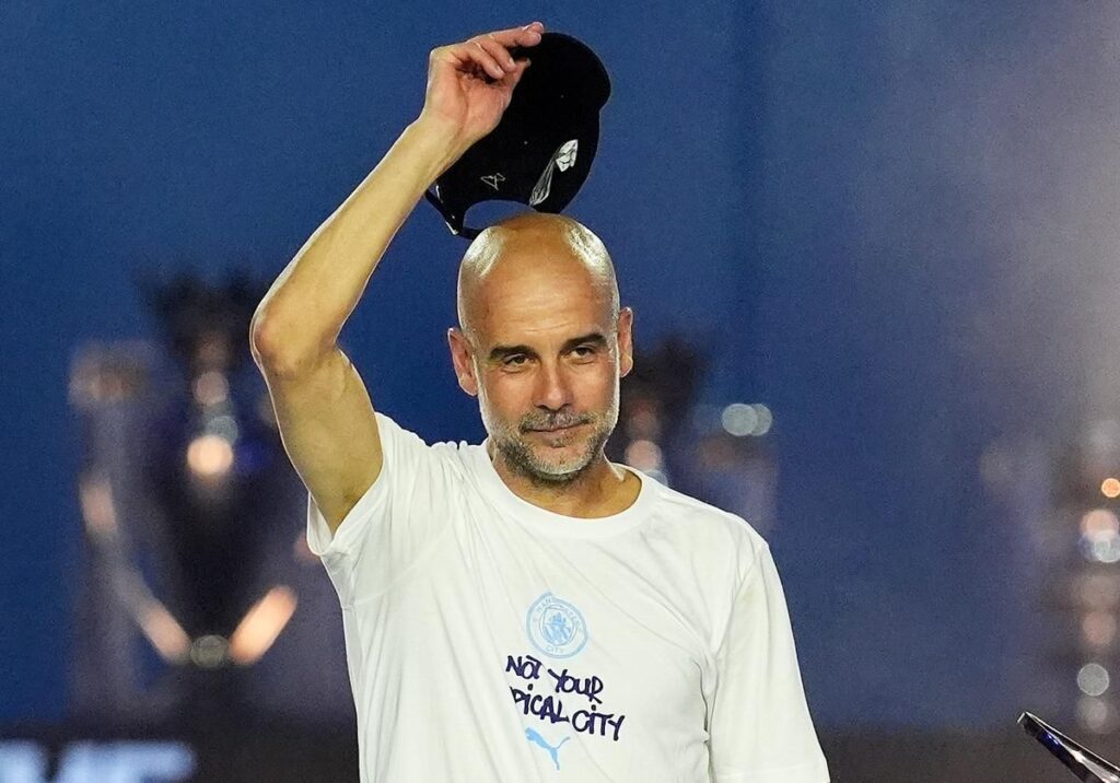 Pep Guardiola standing on the touchline looking thoughtful during a match