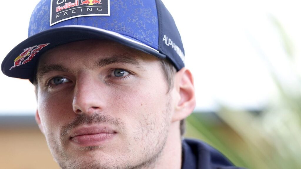 Max Verstappen wearing his Red Bull racing suit while speaking to the media in the Formula 1 paddock
