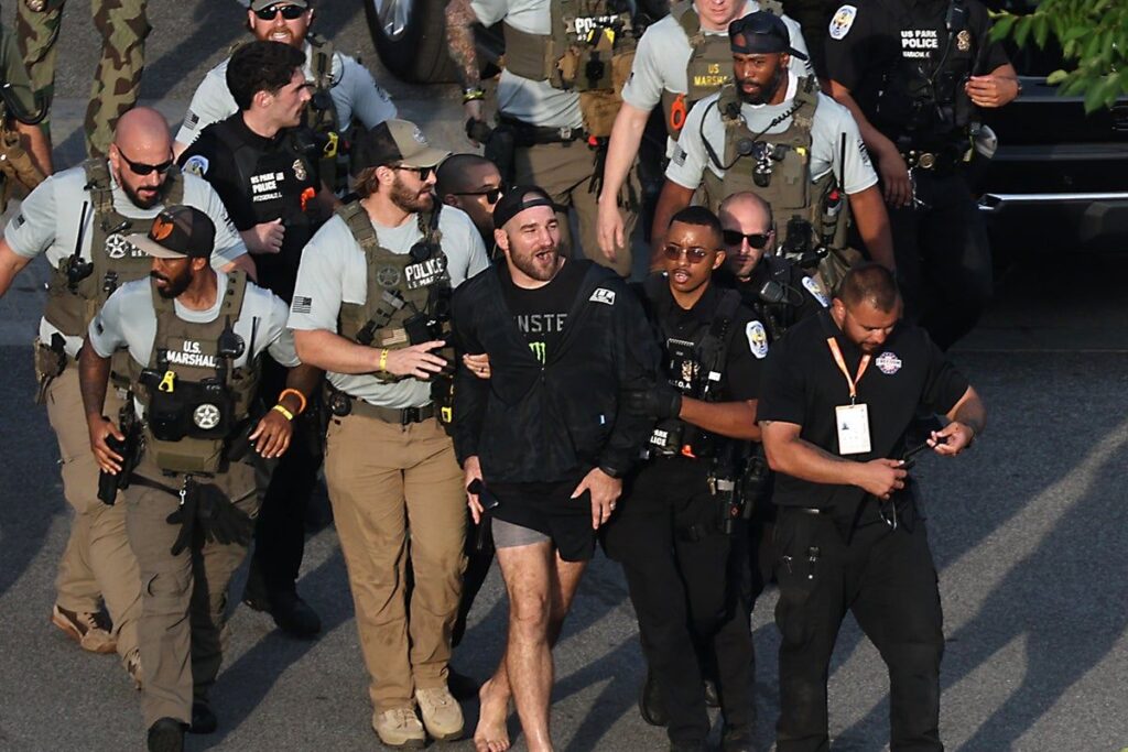 UFC middleweight champion Sean Strickland being escorted by US Secret Service personnel near the White House