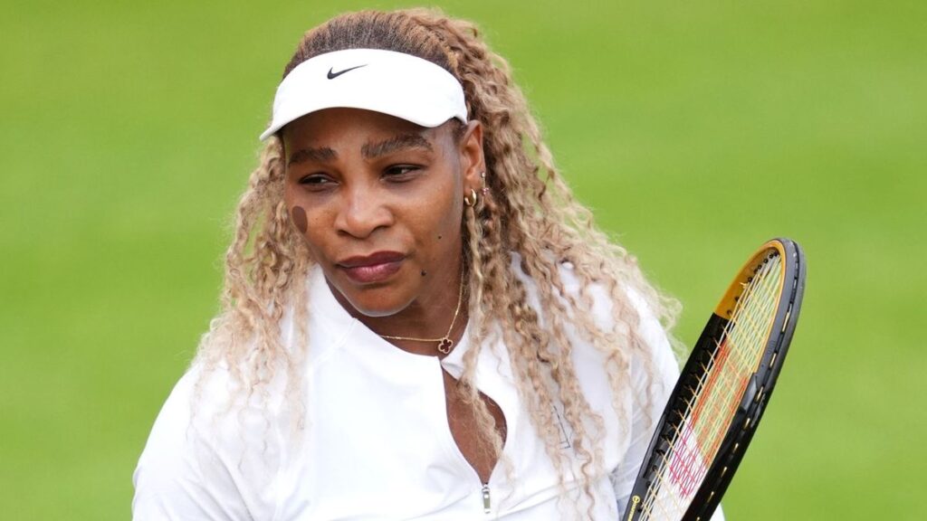 Serena Williams smiling on a grass tennis court during her professional comeback