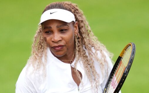 Serena Williams smiling on a grass tennis court during her professional comeback
