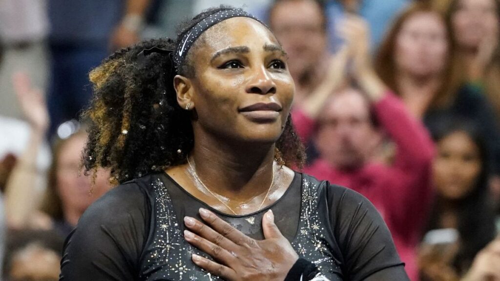 Serena Williams looking focused on a grass tennis court holding her racket